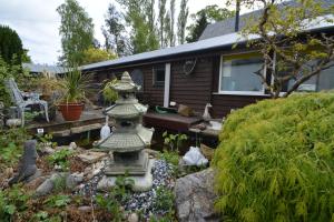 a garden with a stone lantern in front of a house at Craiglockhart Lodge in Edinburgh