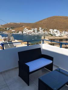 a balcony with a bench and a view of a city at Cycladic house in Kithnos