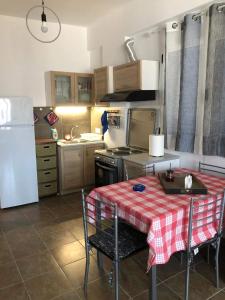 a small kitchen with a table and a refrigerator at Cycladic house in Kithnos