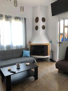 a living room with a couch and a fireplace at Cycladic house in Kithnos