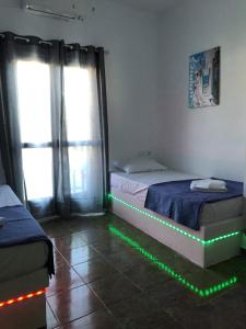 a room with two beds with green lights on the floor at Cycladic house in Kithnos