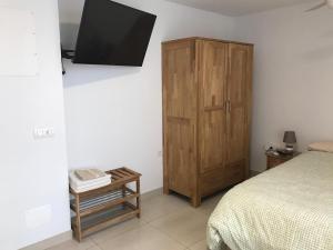 een slaapkamer met een bed en een houten kast bij Estudio nuevo con baño, cocina y gran terraza in Los Realejos