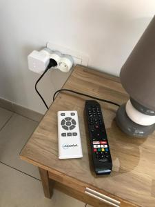 two remote controls sitting on a table next to a lamp at Estudio nuevo con baño, cocina y gran terraza in Los Realejos