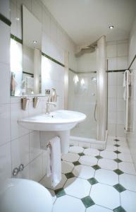 a white bathroom with a sink and a shower at Hotel-Gasthof Zum Weyssen Rössle in Schiltach