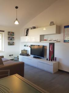 sala de estar con sofá y TV en When in Maremma, en Alberese