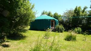 een groene tent in een veld met een tuin bij La Yourte in Moussages