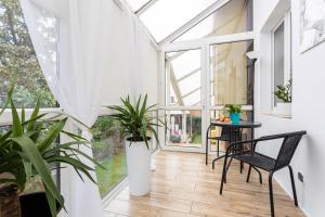 a conservatory with a table and chairs and plants at Dolce Vita in Gdańsk