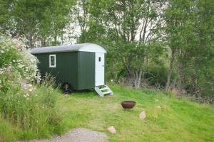 a small green and white shed in a field at Howe of Torbeg in Ballater