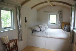 a bed in a room with two windows at Howe of Torbeg in Ballater