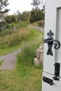 a handle on a door with a view of a yard at Howe of Torbeg in Ballater