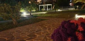 a walkway in a park at night with flowers at Kassiani Studios in Keramoti