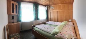 una camera da letto con un letto con testiera in legno di Biobergbauernhof Bergzeit Apartment in Goldegg a Goldegg