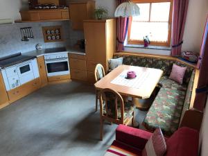 una piccola cucina con tavolo e divano di Biobergbauernhof Bergzeit Apartment in Goldegg a Goldegg Altre 28 foto