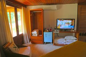 
a bedroom with a television and a bed at Pousada Triboju in Fernando de Noronha
