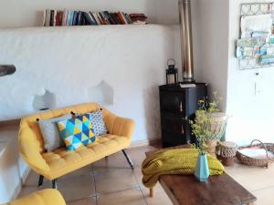 a living room with a yellow couch and a table at Casa ALMA in Hermigua