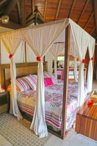 a bed with a canopy in a room at Pousada Triboju in Fernando de Noronha