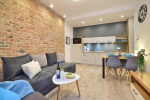 a living room with a couch and a brick wall at CityLife Business Apartament Centrum in Lublin