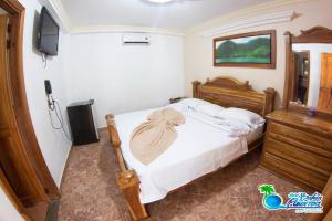 卡普兰干HOTEL BAHÍA PINORROA的卧室里有一张床和一台电视机