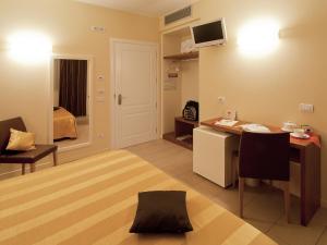 een woonkamer met een bureau en een kamer met een bed bij Hotel Cluentum in Tolentino