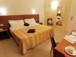una habitación de hotel con una cama grande y una mesa en Hotel Cluentum, en Tolentino