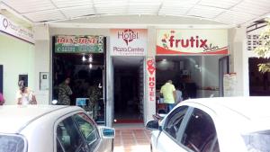 a white car parked in front of a store at Hotel plaza centro in Florencia