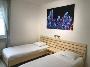 Cette chambre comprend deux lits et un tableau mural. dans l'établissement Apartmán Hodruša-Hámre, à Hodruša