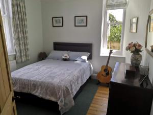 a bedroom with a bed and a guitar in it at Church View House in Drewsteignton