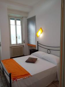 a bedroom with a bed with an orange blanket on it at Rainbow Relais in Lesa