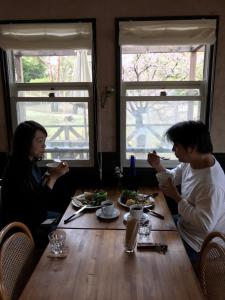 two people sitting at a table eating food at Vegetarian House Jamoo in Yamanakako