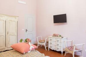 salon z telewizorem, komodą i krzesłami w obiekcie Villa Rambaudi w mieście Sanfrè
