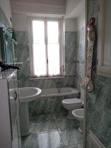 a bathroom with a sink and a toilet and a window at Rainbow Relais in Lesa