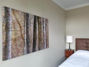 een slaapkamer met een schilderij van bomen aan de muur bij Villa Bianca am Huy in Dingelstedt