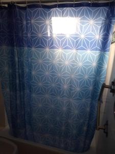 Baño con cortina de ducha azul en Departamento Moderno Y Confortable, en San Miguel de Tucumán