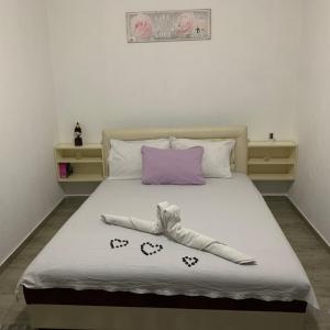 ein Schlafzimmer mit einem Bett mit einem lila Kissen in der Unterkunft Emro-S in Novi Pazar