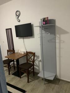 um quarto com uma secretária, uma televisão e uma mesa em Emro-S em Novi Pazar