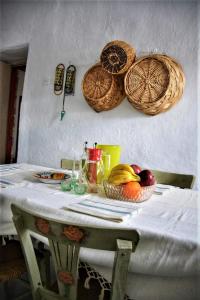 a table with baskets on the wall and fruits on it at Casa di Cardellino in Psarades