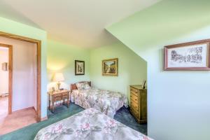 a bedroom with two beds and a table with a lamp at Vermont Getaway in Waterbury Center