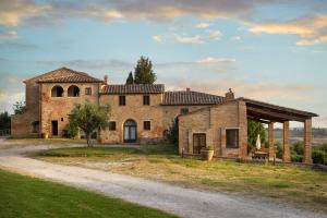 an old stone house on a dirt road at Cosona in Pienza