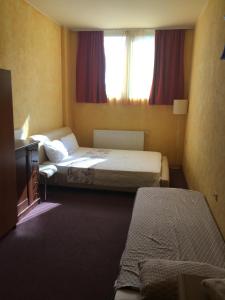 a hotel room with two beds and a television at Motel Sofia in Sežana