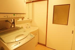 a small bathroom with a washing machine and a sink at Villa alive in Takekara