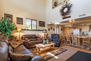a living room with leather furniture and a kitchen at Moose Mountain Retreat in Fish Haven