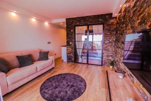 a living room with a couch and a stone wall at The Paradise Monac'Home Parking in Monte Carlo