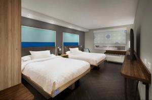 2 Betten in einem Hotelzimmer mit 2 Fenstern in der Unterkunft Tru By Hilton Edinburg in Edinburg