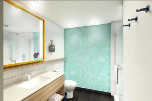 ein Badezimmer mit einem WC, einem Waschbecken und einem Spiegel in der Unterkunft Tru By Hilton Edinburg in Edinburg