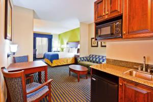 a hotel room with a king bed and a kitchen at Holiday Inn Express Hotel & Suites Ooltewah Springs - Chattanooga, an IHG Hotel in Ooltewah