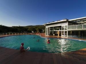 a group of people in a swimming pool next to a building at Jambo Mara Safari Lodge in Ololaimutiek