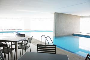 a dining area with a table and chairs and a pool at Begrand Alto Polanco Pool Gym Jacuzzi & More in Mexico City