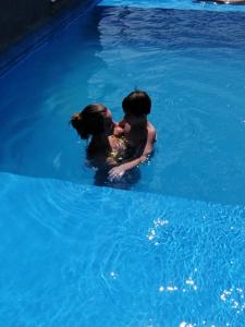 kobieta i dziecko w wodzie w basenie w obiekcie Departamento Moderno Y Confortable w mieście San Miguel de Tucumán