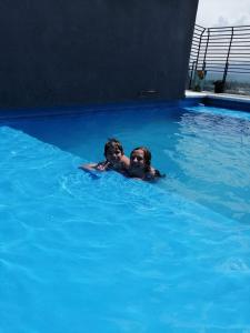 kobieta i dziecko pływające w basenie w obiekcie Departamento Moderno Y Confortable w mieście San Miguel de Tucumán