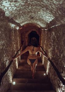 Una donna in bikini nero che cammina in un tunnel di Hotel Zentik Project & Saline Cave a Valladolid